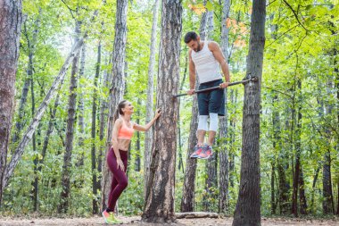 Güçlü erkek ve atletik kadın fitness ve spor yaparken açık spor salonunda egzersiz