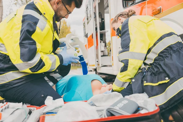 Paramedics performing first aid at ambulance — Stock Photo, Image