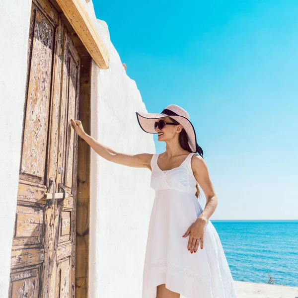 Mulher batendo na porta de uma casa de praia na Grécia — Fotografia de Stock