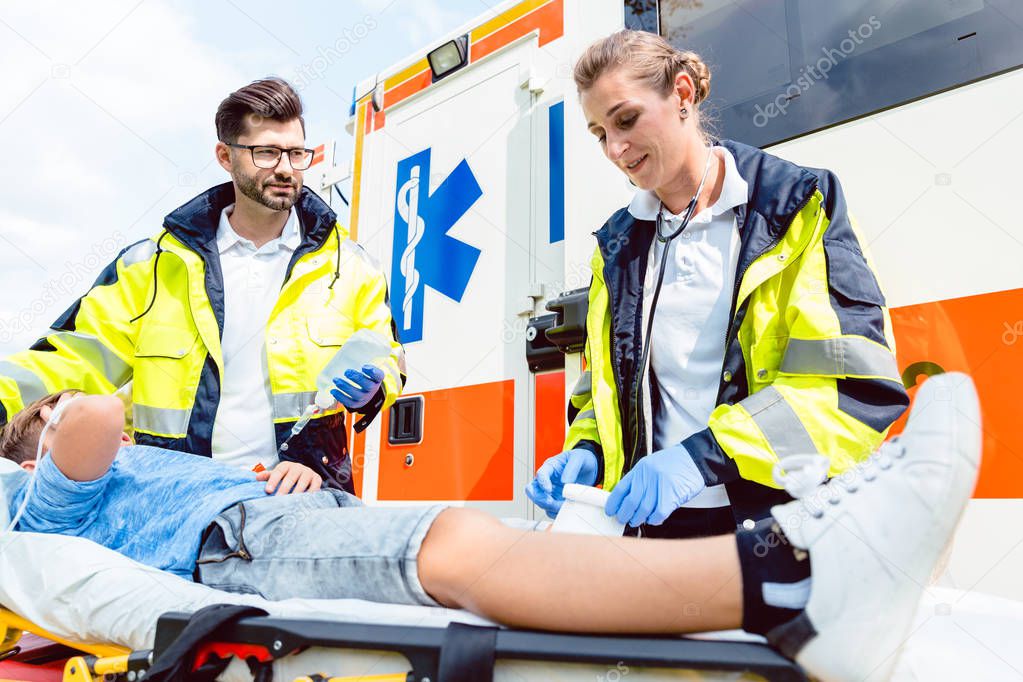 Paramedic and emergency doctor caring for injured boy 