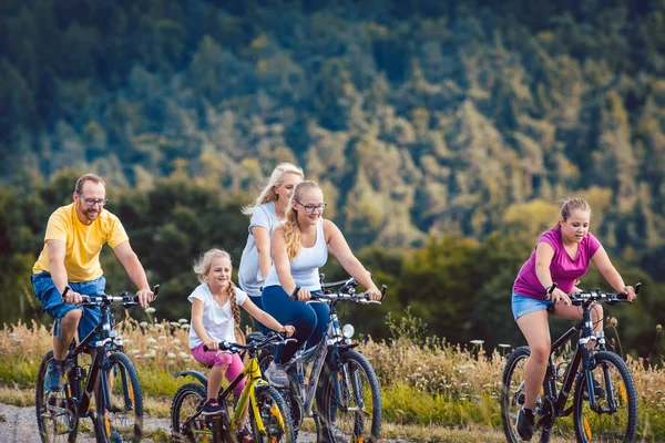 Family riding their bicycles on afternoon in the countryside — Stock Photo, Image