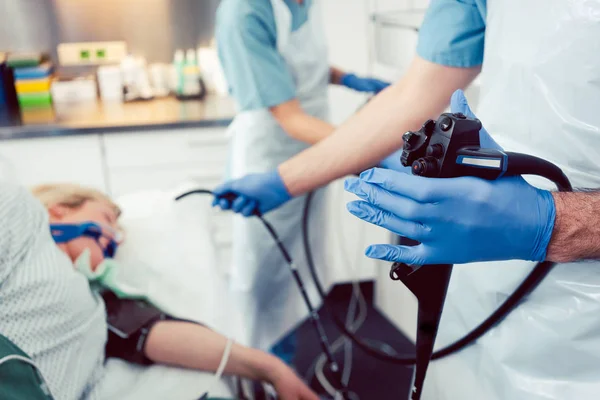 Doctor inserting camera of gastroscope into mouth of patient — Stock Photo, Image