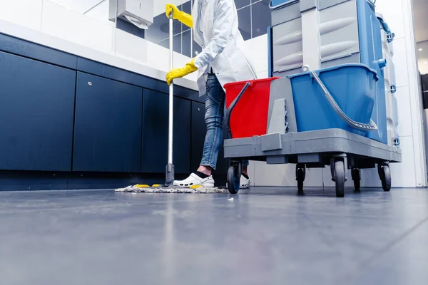 Låg skjuten av städhjälp moppning golvet i toaletten — Stockfoto