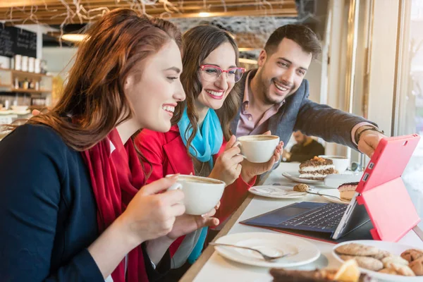 Vrolijke collega's samen kijken naar een grappige video op laptop — Stockfoto