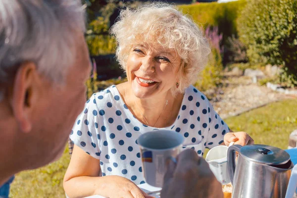 Feliz pareja de ancianos desayunando en su jardín al aire libre —  Fotos de Stock