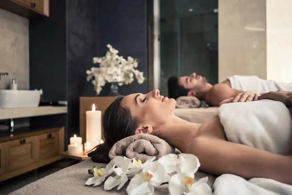 Man and woman lying down on massage beds at Asian wellness center — Stock Photo, Image