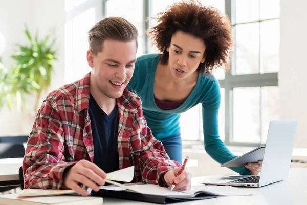 Dos jóvenes estudiantes navegando por Internet para obtener información útil en línea — Foto de Stock