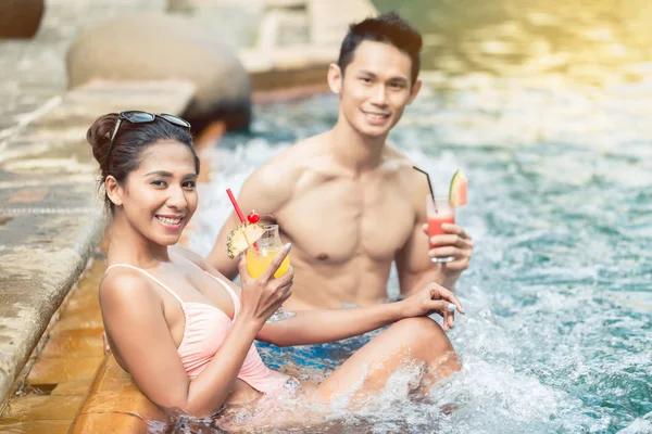 Joven coqueteando con una atractiva mujer en una piscina de moda — Foto de Stock
