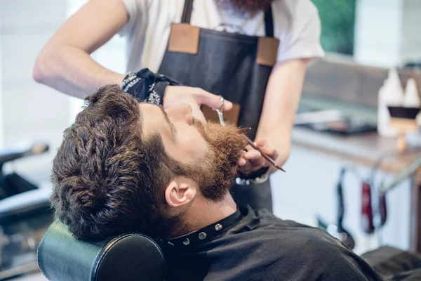 Close-up of the hand of a barber using scissors while trimming — Stock Photo, Image