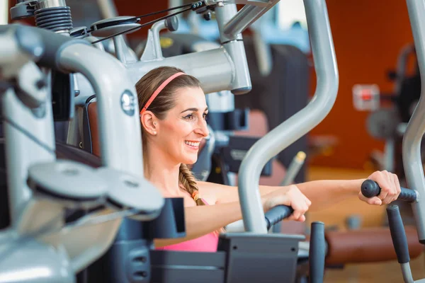 Vista lateral de una mujer alegre haciendo ejercicio durante el entrenamiento de la parte superior del cuerpo —  Fotos de Stock