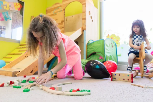 Jolie fille construire une structure en équilibre pendant le temps de jeu à la maternelle — Photo