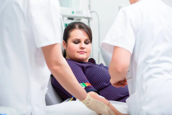 Asistente de médicos revisando el acceso a donante de sangre femenina — Foto de Stock