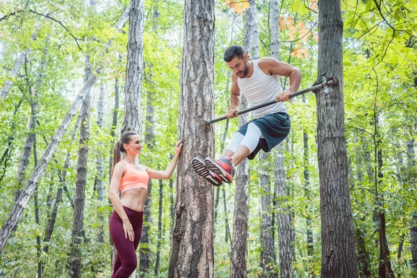 Сильный мужчина и спортивная женщина делают упражнения на открытом воздухе — стоковое фото