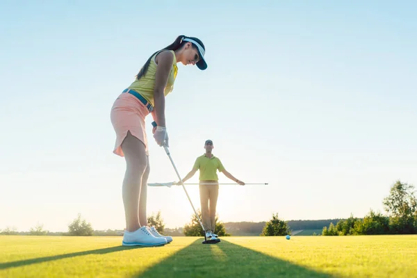 Ajuste mujer ejercicio golpeando técnica durante la clase de golf con —  Fotos de Stock