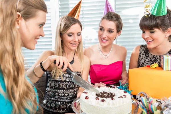 Mulher soprando velas em seu bolo de aniversário enquanto celebra — Fotografia de Stock