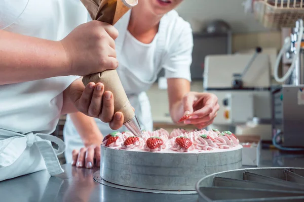 Confeiteiro ou pastelaria Chefs bolo de acabamento com saco de pastelaria — Fotografia de Stock