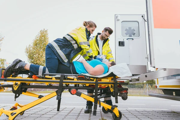 Emergency doctor taking care of seriously injured woman — Stock Photo, Image