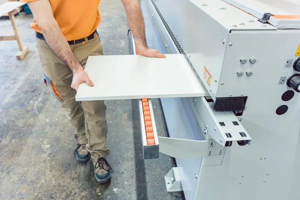 Carpenter in furniture factory working on veneer machine — Stock Photo, Image