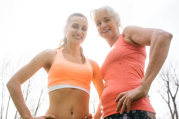 Senior en jonge vrouw doen buiten sport — Stockfoto