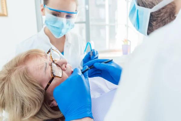 Dentista durante o tratamento de um paciente idoso — Fotografia de Stock