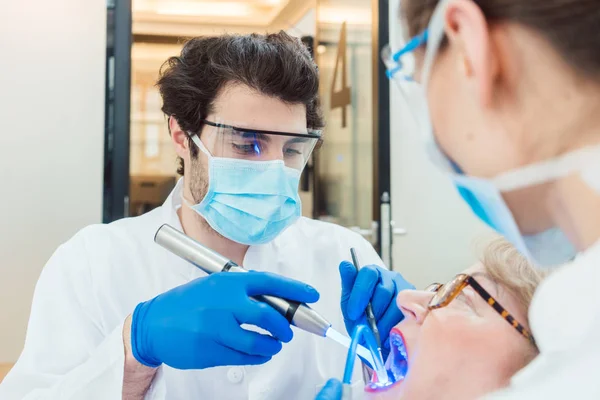 Dentistes durcissant couronne de suie avec lumière UV — Photo
