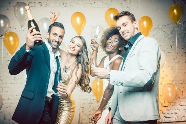 Grupo de mujeres y hombres celebrando con champán — Foto de Stock