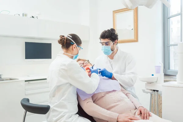 Dentista durante o tratamento da paciente idosa — Fotografia de Stock