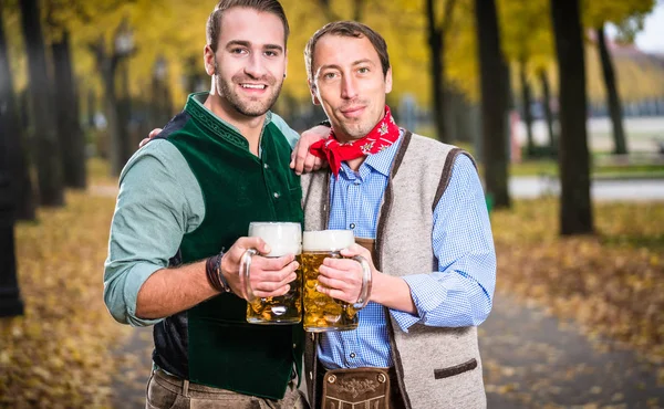 Homens em bayrischer Tracht clinking copos com cerveja — Fotografia de Stock