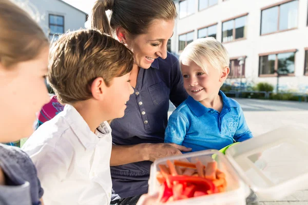 Mamma e bambini a pranzo vegetariano con strisce di peperone — Foto Stock