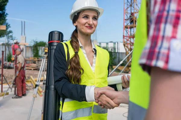 Arquitecto e ingeniero o supervisor estrechando las manos en el sitio de construcción — Foto de Stock