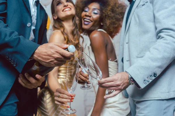 Homem que abre garrafa de champanhe em celebração no clube — Fotografia de Stock