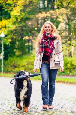 Annesi şemsiyesi sonbahar yürüyüş taşıyan köpek