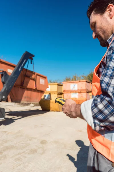 Man lastning av konstruktion skräp behållare på lastbil — Stockfoto