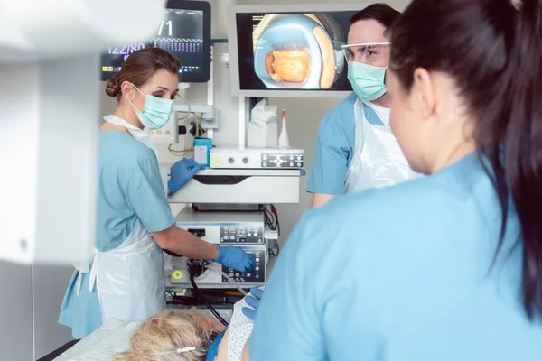 Squadra di medici in ospedale in endoscopia esaminando le immagini — Foto Stock