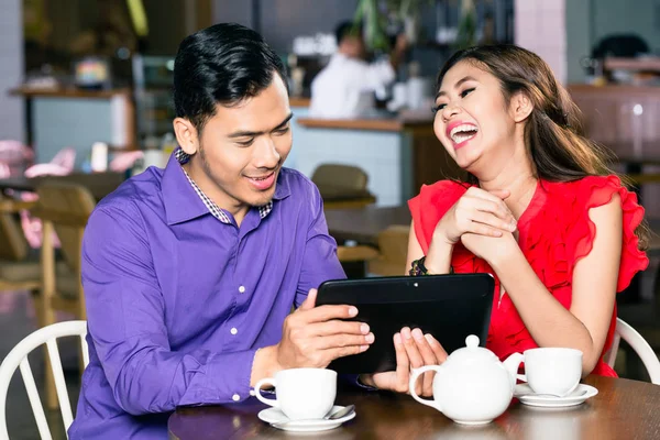 Joven hombre viendo un divertido video en la tableta junto a su novia — Foto de Stock