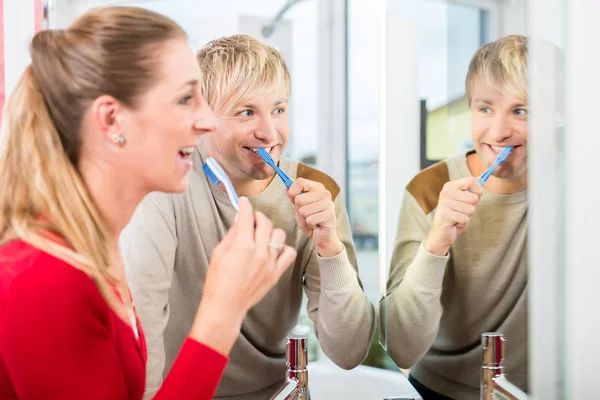 Happy man looking in the mirror next to his wife in a modern shop — Stock Photo, Image