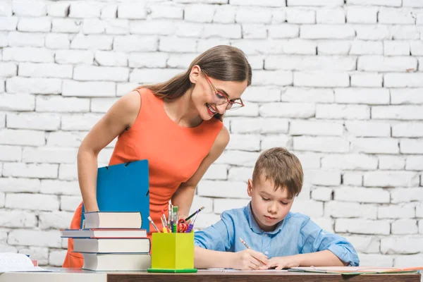 Mãe ajudando seu filho a fazer os trabalhos de casa da escola — Fotografia de Stock