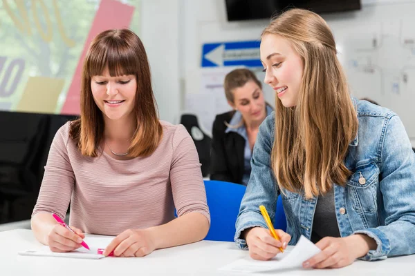 Students writing test or exam after finishing their driving lessons — Stock Photo, Image