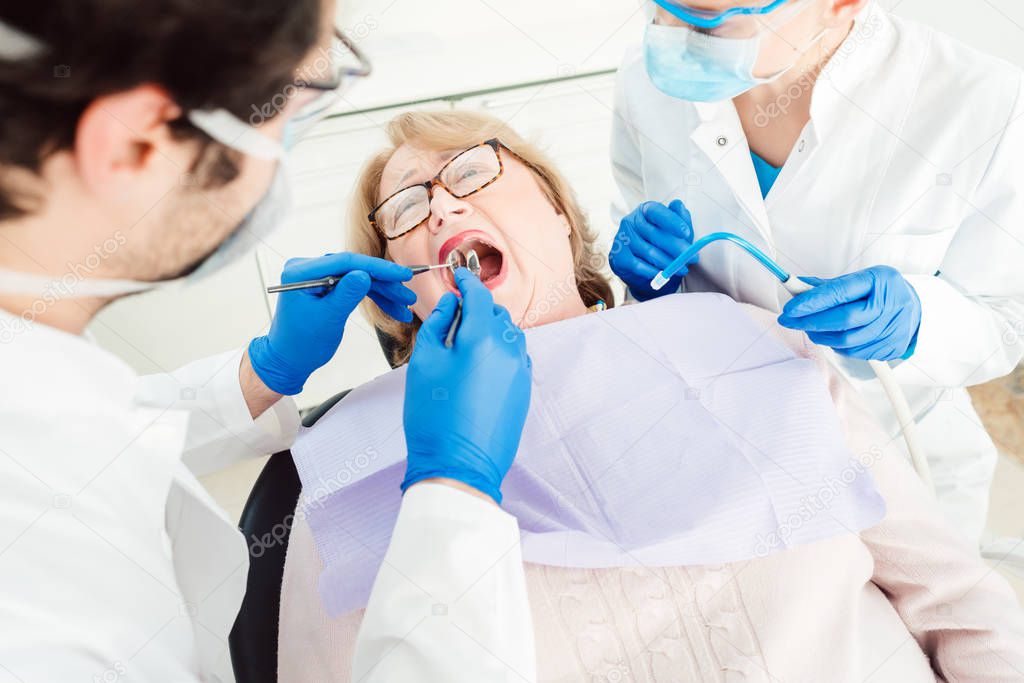 Dentist during treatment of a senior patient
