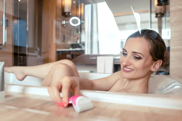 Femme ayant bain dans la baignoire de l'hôtel saisissant son rasoir — Photo