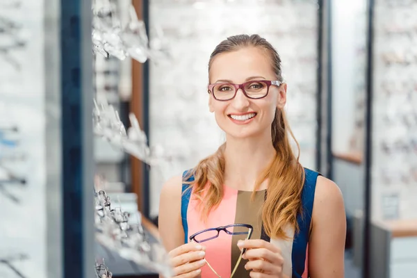 Donna che è soddisfatto con i nuovi occhiali che ha comprato nel negozio — Foto Stock