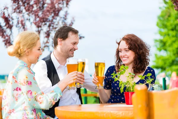 Brindisi con gli amici con birra nel ristorante in giardino — Foto Stock