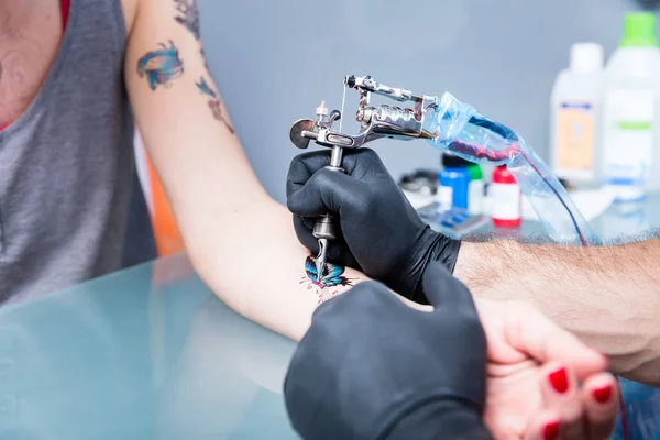 Close-up van de handen van een geschoolde tatoeëerder zwarte handschoenen — Stockfoto