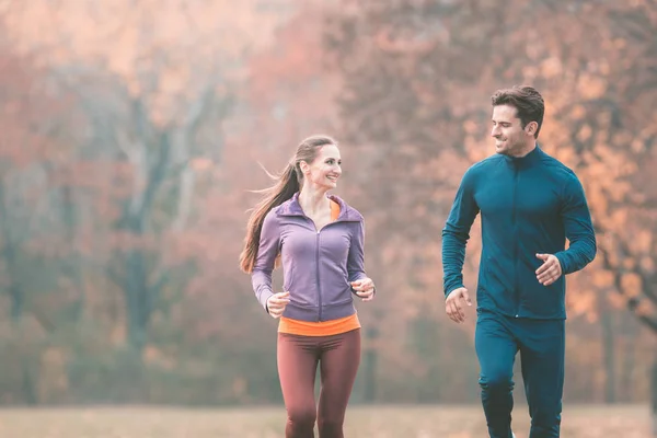 Pareja en maravilloso paisaje de otoño corriendo para una mejor aptitud — Foto de Stock