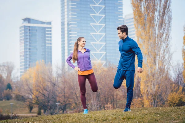 Sportovní pár dělá zahřívací cvičení před zahájením běhu — Stock fotografie