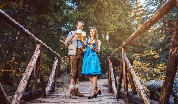 Mulher e homem com cerveja em pé na ponte na Baviera — Fotografia de Stock