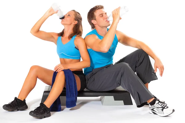 Uomo e donna sportivi che bevono acqua dopo l'allenamento — Foto Stock