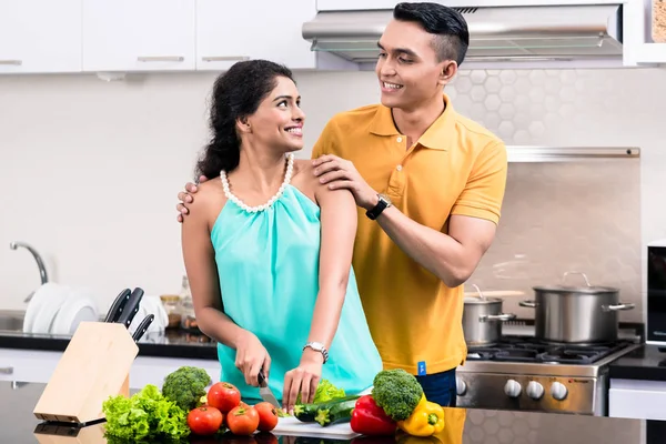 Junges lächelndes Paar in der Küche schaut einander an — Stockfoto