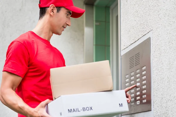 Leverans man transporterar post paket användning av intercom — Stockfoto