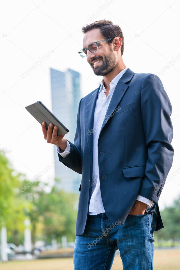 Stylish businessman looking at digital tablet